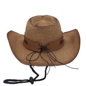 Detail of vintage woven texture on brown straw cowboy hat with leather band and chin strap