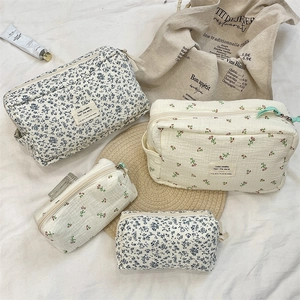 Close-up of quilted cotton floral cosmetic bags with blue flower patterns and metal zippers