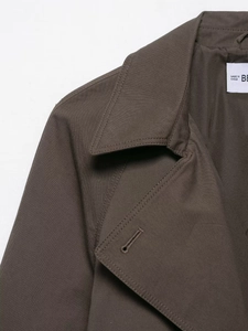 Nahaufnahme von Premium-Nähten und Knopfloch an einem khakifarbenen Baumwoll-Trenchcoat