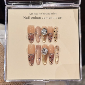 Détail de faux ongles de luxe avec motif léopard, paillettes œil de chat et cristaux