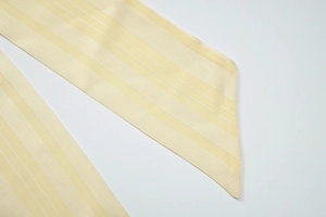 Close-up of light yellow striped fabric accessory with neat diagonal stitching detail