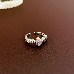 Detail of pink oval zircon ring with micro-pave crystals on a leather background