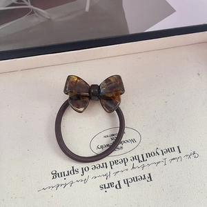Detail of tortoise shell acetate bow hair tie with France Handmade gold engraving