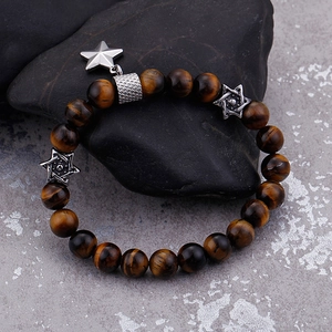 Tiger eye beaded bracelet with silver star charms on rock display for couples