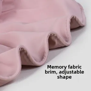 Dettaglio macro della visiera rosa in seta di memoria con trama pieghevole e flessibile