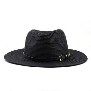 Détail du chapeau de paille noir avec ruban en cuir et boucle en métal doré chic