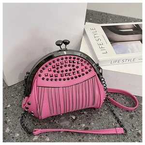 Close-up of pink shell clutch bag with black studs, tassels, and dual chain straps