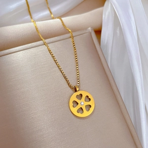 Detailed close-up of a gold four-leaf clover pendant on a premium box chain