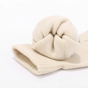 Close-up of soft cream knitted fabric showing fine ribbing and thick texture detail