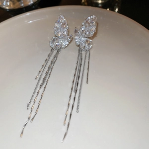Detailed macro view of silver butterfly tassel earrings with sparkling zircon inlay