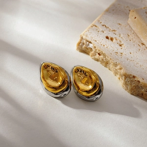 Vue détaillée des boucles d'oreilles bicolores avec texture de lave dorée et argentée