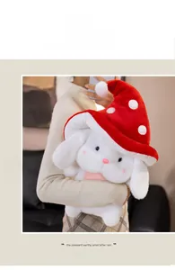 Détail d'un lapin en peluche blanc avec un chapeau champignon rouge à pois blancs