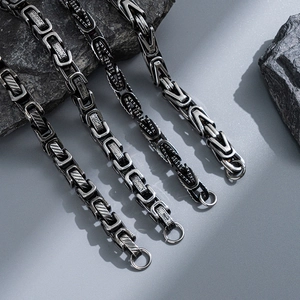 Mens stainless steel hip hop chain bracelets displayed on grey volcanic rocks