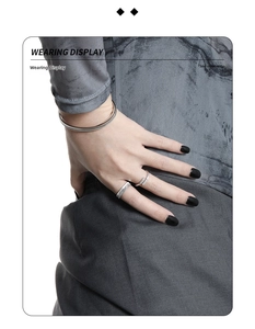 Detail of silver vertical striped ring and diamond band paired with a minimalist bracelet