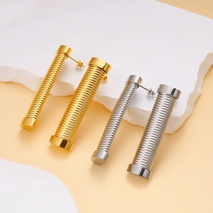 Minimalist 18K gold and silver stainless steel cylinder earrings on a stone stand