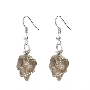 Detailed macro view of handmade wire-wrapped raw smokey quartz crystal earrings