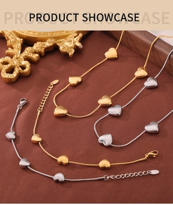 Detail of heart pendant necklace and bracelet set in gold and silver snake chain style
