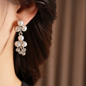Détail de boucles d'oreilles de mariée avec perles blanches et zircons étincelants