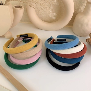Close-up of assorted handmade padded headbands with woven fabric and brand labels