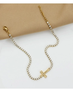 Macro detail of gold-plated stainless steel cross tennis bracelet with zircon inlay