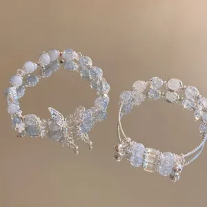 Detailed close-up of beaded bracelets with crystal butterflies on a reflective surface