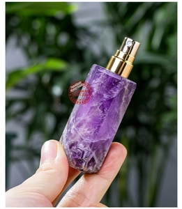 Makroaufnahme der facettierten Amethyst-Parfümflasche mit goldener Metall-Sprühdüse