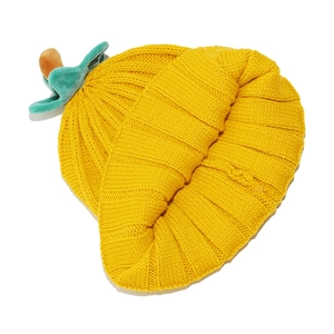 Close-up of bright yellow pumpkin knitted hat showing thick ribbed texture and green stem