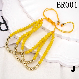 Close-up of yellow beaded bracelets with gold beads and adjustable woven cords