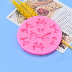 Pink silicone bow mold for fondant and chocolate on light blue decorative background