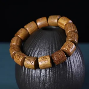 Macro detail of Argentine Green Sandalwood barrel beads with engraved blessing symbols