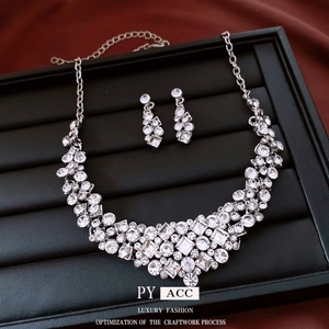 Silver vintage diamond necklace and earring set with round rhinestones on black tray
