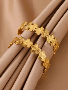 Détail de joncs en acier inoxydable plaqué or 18K avec motifs de fleurs et feuilles