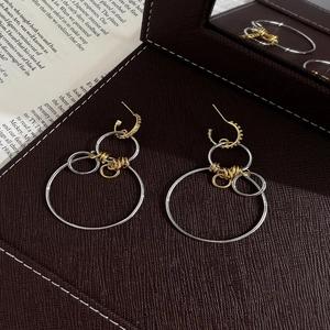 Boucles d'oreilles créoles géométriques bicolores avec détails torsadés dorés et argentés