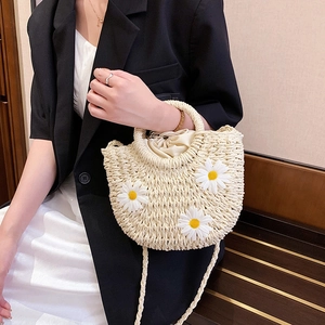 Detail einer Strohtasche mit Gänseblümchen, runden Griffen und Kordelzug-Innenfutter