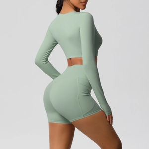 Zijaanzicht van lichtgroene yoga crop top en high-waist biker shorts met zakken