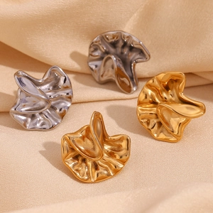 Detailed view of irregular pleated earrings in 18K gold and silver finishes on silk