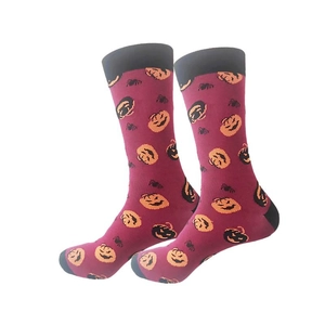Detail of Halloween socks with pumpkin and spider patterns on purple knit fabric