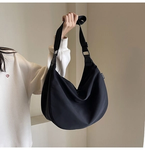 Detail view of the black waterproof Oxford fabric dumpling bag with a fashion label