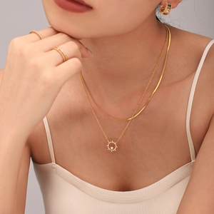 Ensemble collier double couche tournesol doré et bijoux en zircon porté par un mannequin