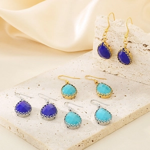 Boucles d'oreilles gouttes en verre avec crochets or et argent sur support pierre