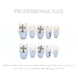 Detail of blue gradient press-on nails with silver metal crosses and rhinestones