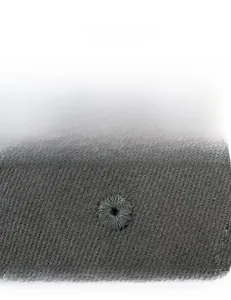 Detail of embroidered eyelet on black cotton twill fabric for breathable comfort