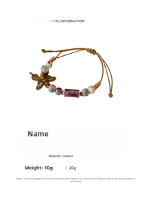 Close-up of vintage ceramic bead bracelet with bronze butterfly charm and woven cord