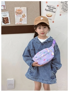 Detail of lavender kids chest bag with cute cartoon prints worn by a young model