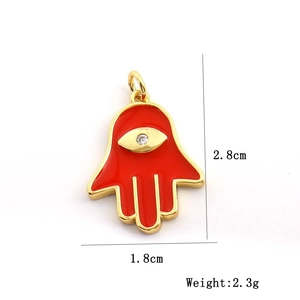 Macro del ciondolo Hamsa rosso da 2,8 cm con bordi dorati e pietra centrale in zircone