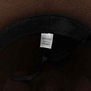 Detail view of western cowboy hat interior featuring 100% polyester label and adjustable strap