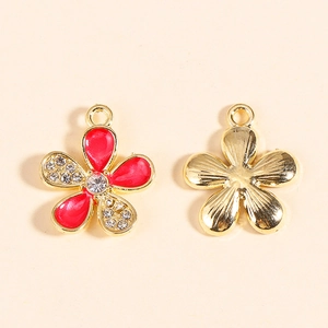 Detail of red enamel flower pendant with rhinestones and gold alloy plating
