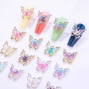 Macro view of crystal butterfly nail art charms with gradient resin and metal frames