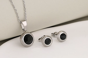 Detailed shot of silver bezel set black round gemstone pendant necklace and earring set