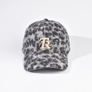 Detail of plush leopard print texture and white TR letter embroidery on a winter baseball cap